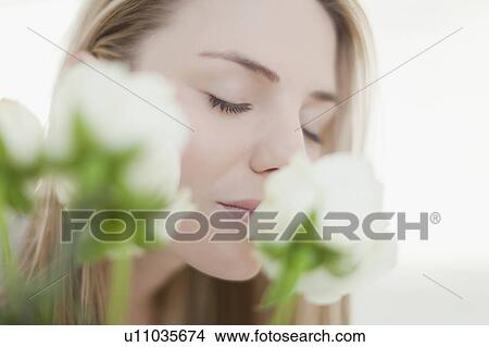 Close up of woman smelling flowers View Large Photo Image Picture - Close up of woman smelling flowers. Fotosearch