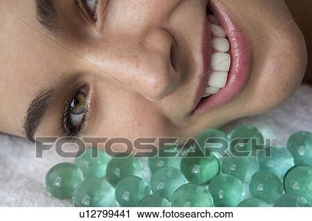 Stock Image - Close up of woman with glass beads. Fotosearch
