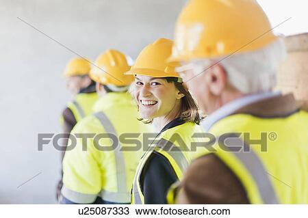 Stock Image - Construction worker smiling on site. Fotosearch