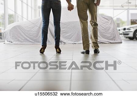 Couple admiring new car under cloth View Large Photo Image Stock Image - Couple admiring new car under cloth. Fotosearch