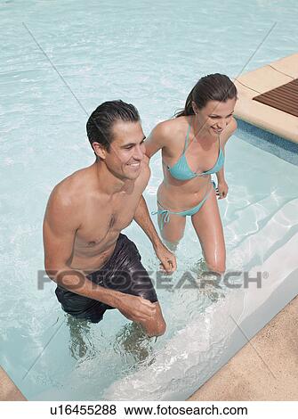 Stock Photo - Couple climbing out of swimming pool. Fotosearch