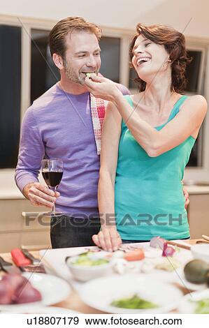 Couple eating and cooking dinner View Large Photo Image Stock Photo - Couple eating and cooking dinner. Fotosearch