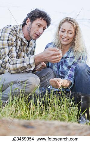 Couple examining seeds outdoors View Large Photo Image Picture - Couple examining seeds outdoors. Fotosearch