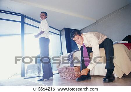 Stock Photography - Couple getting ready for work in bedroom. Fotosearch
