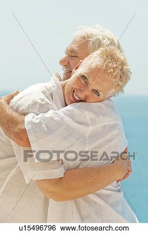 Couple hugging and overlooking sea View Large Photo Image Stock Photograph - Couple hugging and overlooking sea. Fotosearch