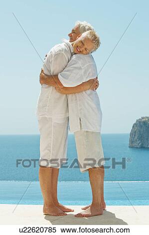 Couple hugging and overlooking sea View Large Photo Image Stock Photography - Couple hugging and overlooking sea. Fotosearch