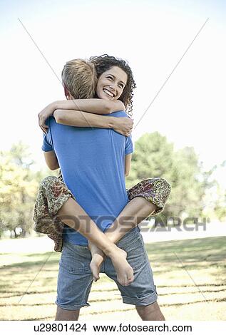 Couple hugging in park View Large Photo Image Picture - Couple hugging in park. Fotosearch