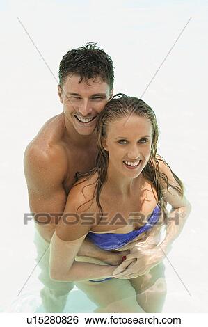 Couple hugging in swimming pool View Large Photo Image Stock Photograph - Couple hugging in swimming pool. Fotosearch