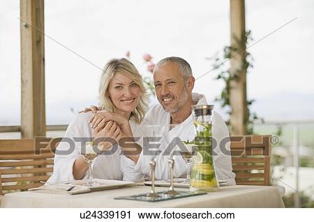 Stock Image - Couple in bathrobes having breakfast. Fotosearch
