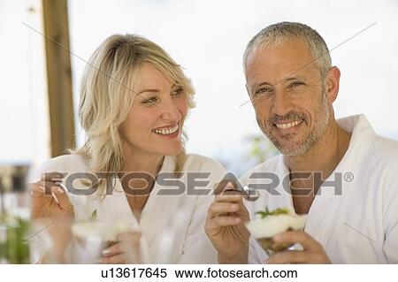 Stock Photography - Couple in bathrobes having breakfast. Fotosearch