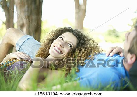 Couple laying in grass together View Large Photo Image Picture - Couple laying in grass together. Fotosearch