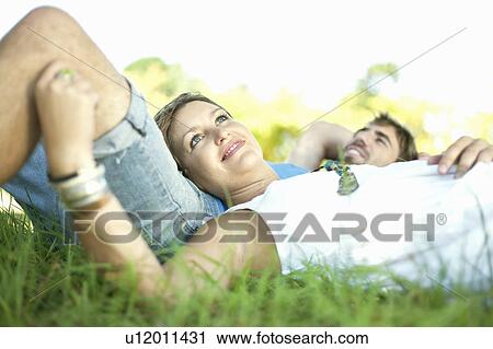 Couple laying in grass together View Large Photo Image Stock Image - Couple laying in grass together. Fotosearch