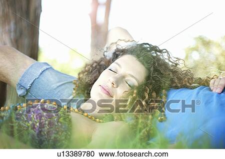 Stock Image - Couple laying in grass together. Fotosearch