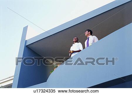 Stock Photography - Couple overlooking view from balcony. Fotosearch