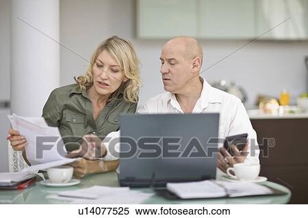 Couple paying their bills at home View Large Photo Image Stock Photography - Couple paying their bills at home. Fotosearch