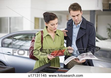 Stock Photography - Couple picking out swatches in showroom. Fotosearch