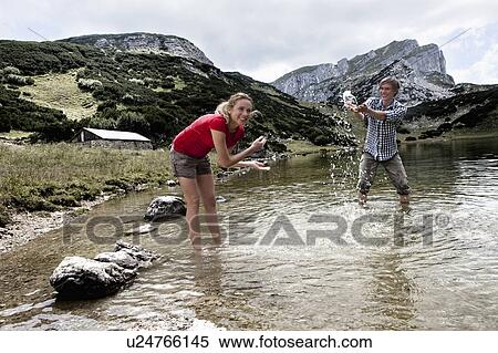 Couple playing in rocky lake View Large Photo Image Stock Photography - Couple playing in rocky lake. Fotosearch