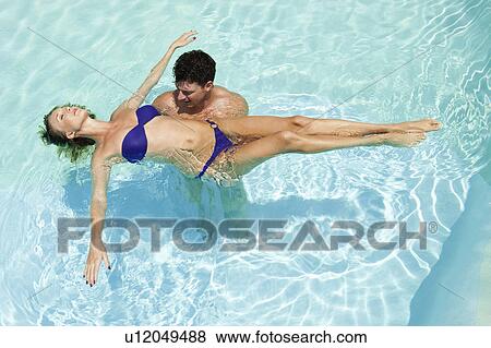 Couple playing in swimming pool View Large Photo Image Stock Photo - Couple playing in swimming pool. Fotosearch