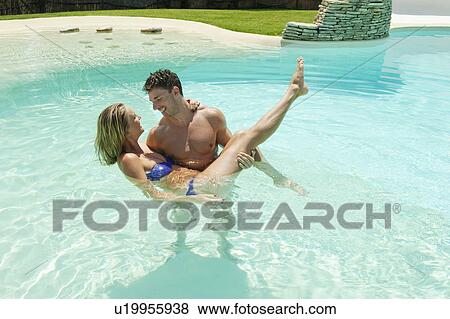 Couple playing in swimming pool View Large Photo Image Stock Photo - Couple playing in swimming pool. Fotosearch