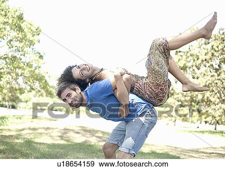 Couple playing together in park View Large Photo Image Stock Photo - Couple playing together in park. Fotosearch