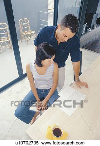 Couple reading together in kitchen View Large Photo Image Stock Photography - Couple reading together in kitchen. Fotosearch