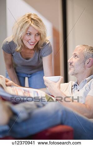 Couple relaxing in living room View Large Photo Image Stock Image - Couple relaxing in living room. Fotosearch