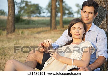 Couple relaxing in park View Large Photo Image Stock Image - Couple relaxing in park. Fotosearch