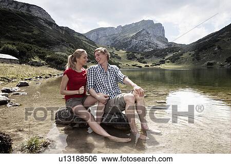 Couple relaxing in rocky lake View Large Photo Image Stock Photograph - Couple relaxing in rocky lake. Fotosearch