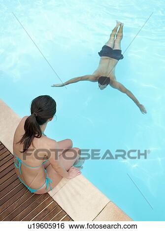 Stock Photograph - Couple relaxing in swimming pool. Fotosearch