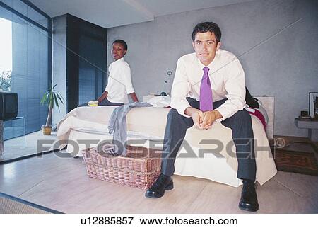 Stock Photo - Couple sitting on bed. Fotosearch