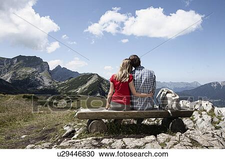 Couple sitting on bench on hilltop View Large Photo Image Stock Image - Couple sitting on bench on hilltop. Fotosearch