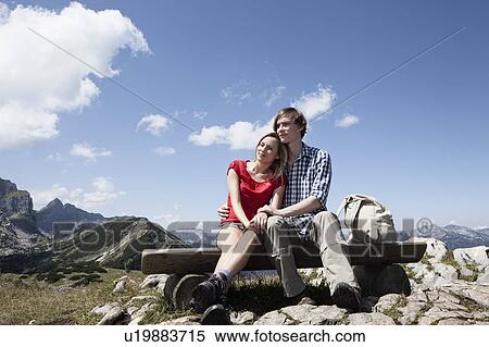 Couple sitting on bench on hilltop View Large Photo Image Stock Photography - Couple sitting on bench on hilltop. Fotosearch