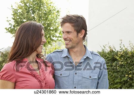 Stock Image - Couple smiling at each other outdoors. Fotosearch