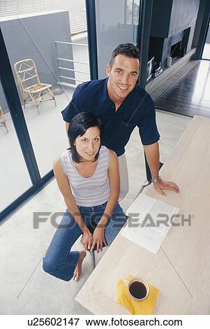 Stock Photo - Couple smiling together in kitchen. Fotosearch