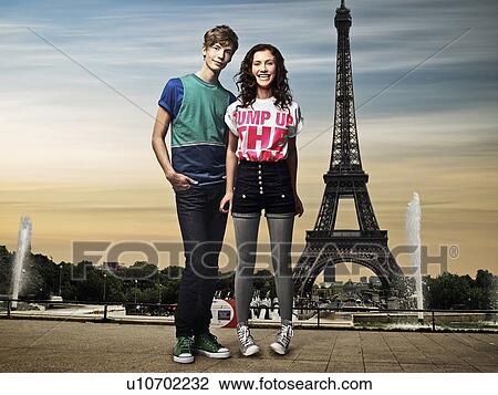 Stock Image - Couple standing in front of Eiffel Tower. Fotosearch