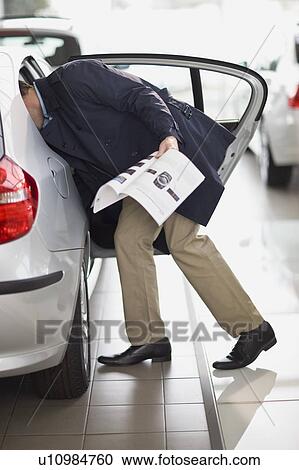 Customer examining car in showroom View Large Photo Image Stock Image - Customer examining car in showroom. Fotosearch