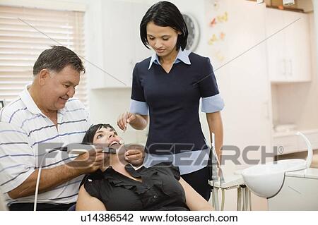 Dentist and assistant working on woman View Large Photo Image Stock Image - Dentist and assistant working on woman . Fotosearch