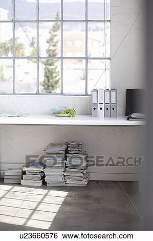 Stock Photograph - Desk and stacks of paper in office. Fotosearch