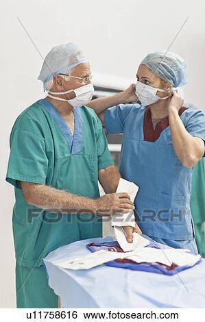 Stock Photograph - Doctor and nurse in operating room. Fotosearch