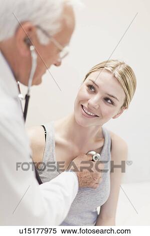 Stock Photography - Doctor listening to patient’s heartbeat. Fotosearch