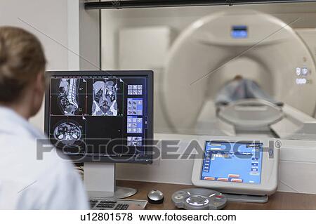 Doctor operating CT scanner in hospital View Large Photo Image Stock Photo - Doctor operating CT scanner in hospital. Fotosearch