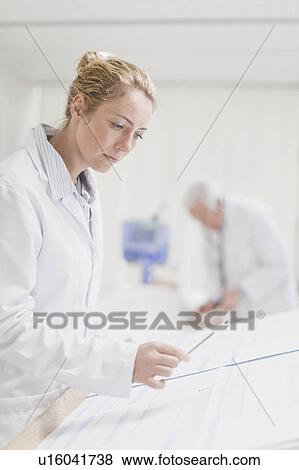 Stock Photo - Doctor reading patient’s chart. Fotosearch
