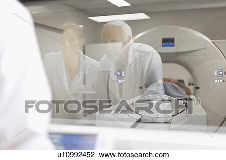 Doctors operating CT scanner in hospital View Large Photo Image Stock Image - Doctors operating CT scanner in hospital. Fotosearch