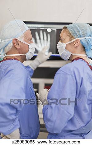 Doctors reading x-rays in operating room View Large Photo Image Stock Photography - Doctors reading x-rays in operating room. Fotosearch