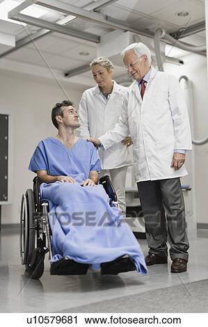 Doctors talking to patient in wheelchair View Large Photo Image Stock Image - Doctors talking to patient in wheelchair. Fotosearch