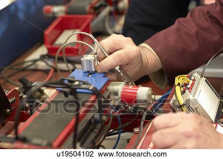 Stock Image - Electrical engineer working in shop. Fotosearch