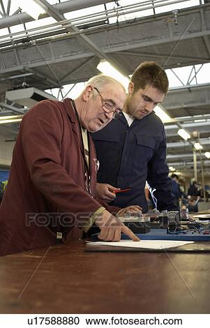 Stock Image - Electrical engineers working in shop. Fotosearch