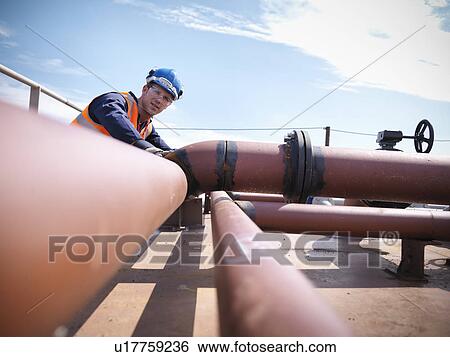 Engineer inspecting ship parts View Large Photo Image Stock Photograph - Engineer inspecting ship parts. Fotosearch