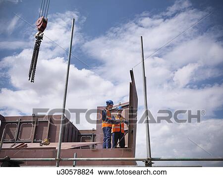 Picture - Engineers examining ship parts. Fotosearch