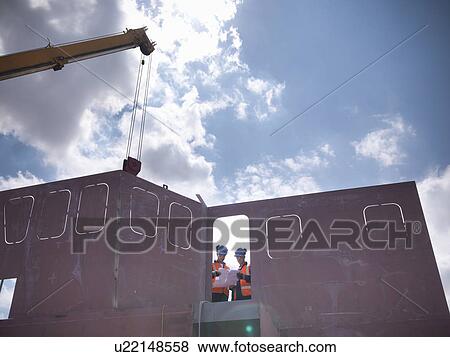 Stock Photo - Engineers examining ship parts. Fotosearch